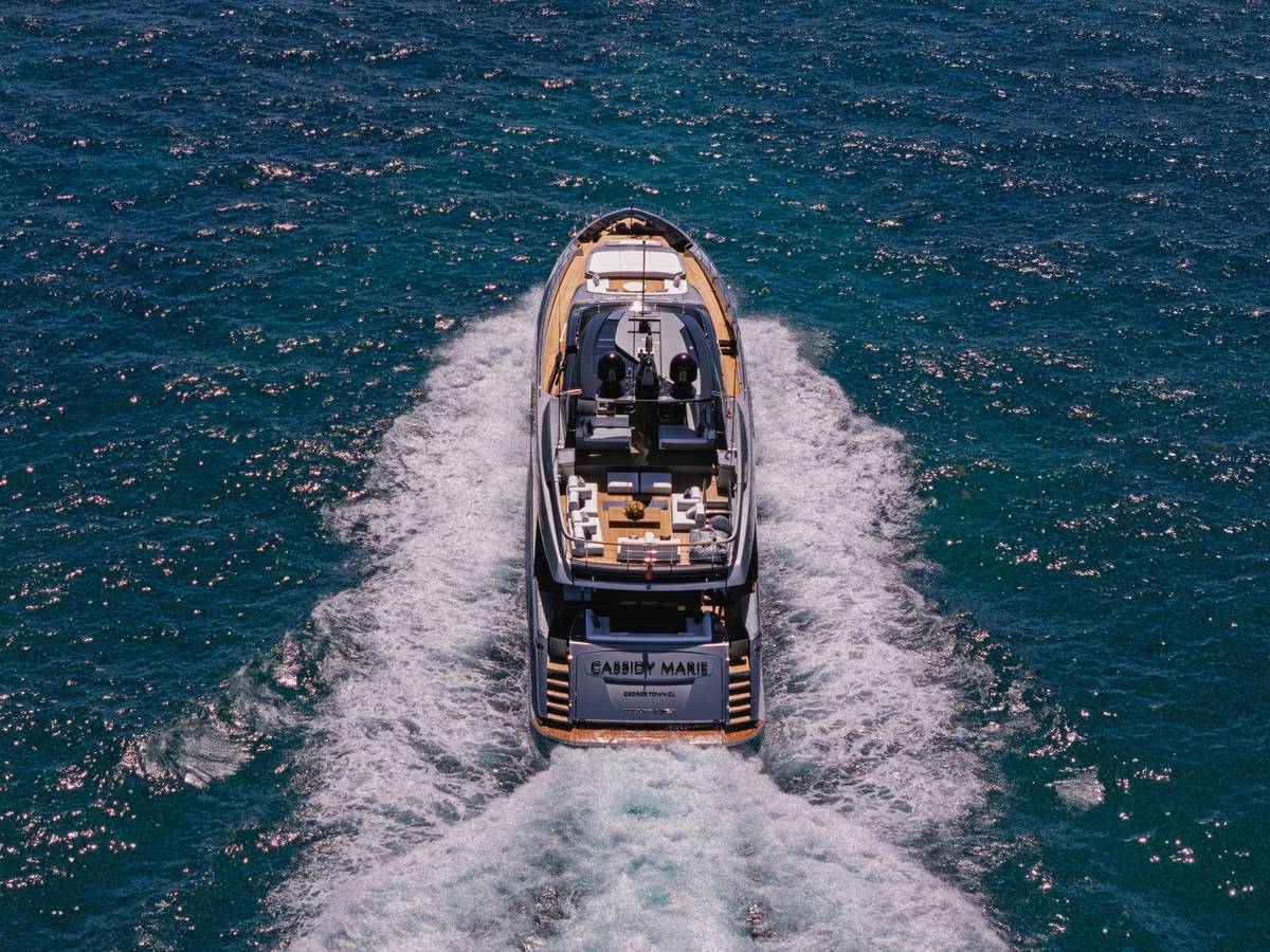 Elite yacht insurance quotes compared side-by-side on a tablet next to a yacht docked in Monaco harbor